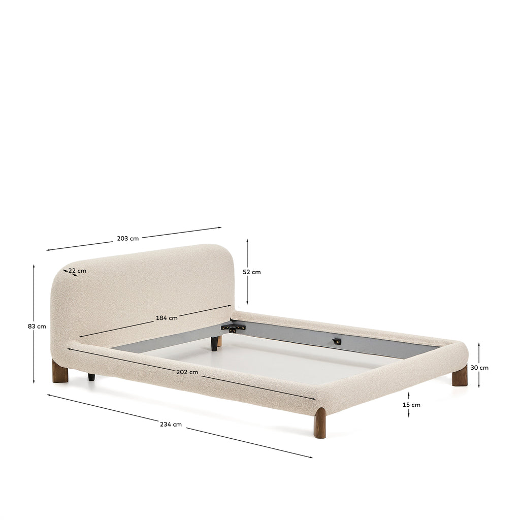 Llit desenfundable Odina bouclé cru i potes de fusta massissa de freixe amb acabat en to noguera per a matalàs de 180x200 cm